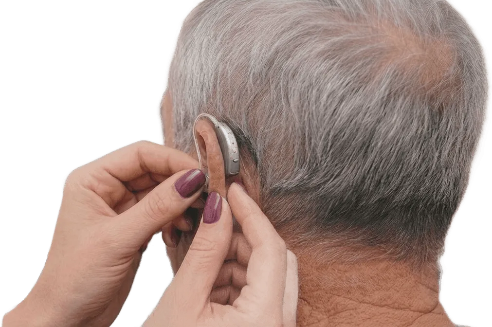 קלינאית תקשורת מכווננת מכשיר שמיעה מאחורי האוזן במהלך פגישת התאמה.