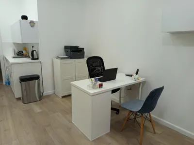 אזור הקבלה במכון, עם פינת מטבחון ושולחן עבודה מואר.